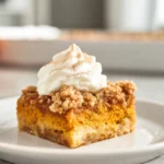 hero image of pumpkin dump cake recipe served on a modern plate with warm fall flavors