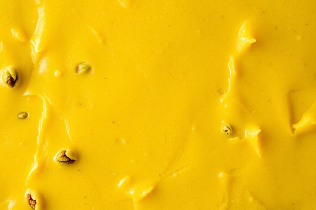 A closeup view of freshly made pistachio fudge, showcasing its luscious texture and rich color. The surface is smooth and glossy, with a slight sheen that catches the light. Tiny flecks of vibrant green pistachio kernels are visible throughout the creamy, indulgent confection. Warm lighting from above casts soft shadows, emphasizing the depth and luxurious mouthfeel of the fudge. The composition is tightly framed, filling the frame and drawing the viewer's attention to the decadent texture. A sense of artisanal craft and attention to detail is evident in every aspect of the image. A closeup view of freshly made pistachio fudge, showcasing its luscious texture and rich color. The surface is smooth and glossy, with a slight sheen that catches the light. Tiny flecks of vibrant green pistachio kernels are visible throughout the creamy, indulgent confection. Warm lighting from above casts soft shadows, emphasizing the depth and luxurious mouthfeel of the fudge. The composition is tightly framed, filling the frame and drawing the viewer's attention to the decadent texture. A sense of artisanal craft and attention to detail is evident in every aspect of the image.