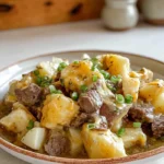 Crockpot Loaded Steak And Potato Bake Recipe served on a ceramic plate in a cozy home kitchen