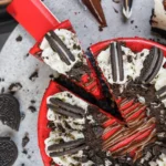 Heavenly Red Velvet Oreo Cheesecake slice on modern plate with Oreo crust