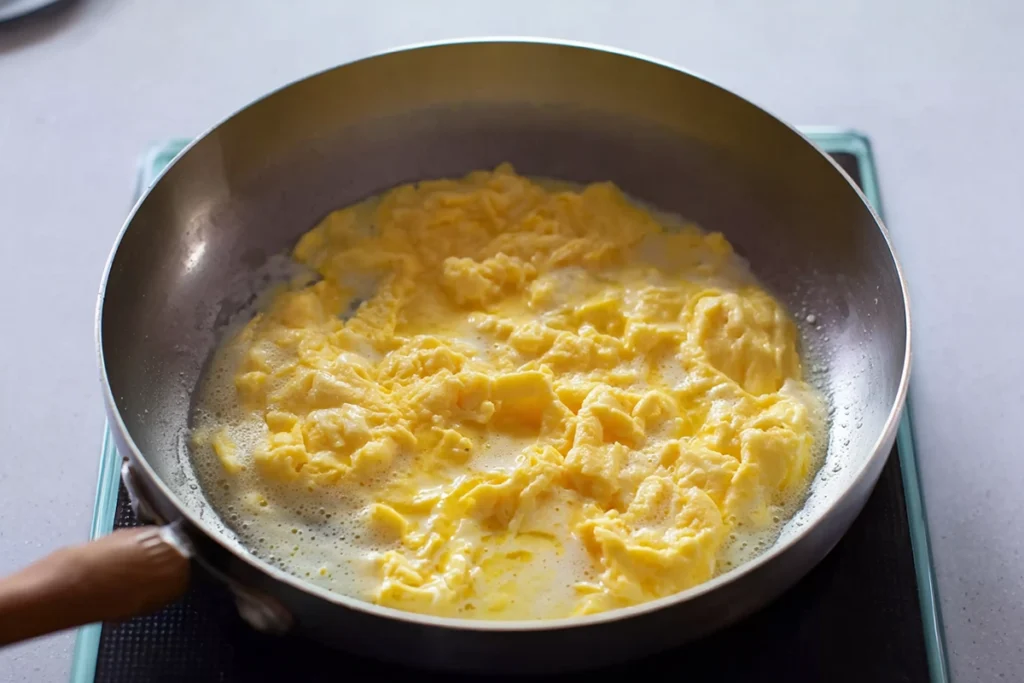 soft folded eggs cooking for steak egg and cheese bagel sandwich