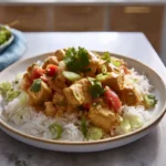 Thai chicken coconut curry served over white rice on a modern ceramic plate
