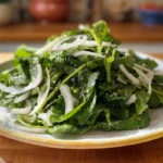 Fresh dandelion salad recipe plated with olive oil and lemon in a cozy home kitchen