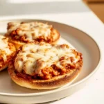 Homemade pizza burgers served open-faced with melted cheese and saucy topping