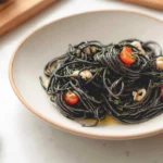homemade squid ink pasta plated in a modern American kitchen