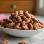 easy candied almonds on a ceramic plate in a cozy home kitchen