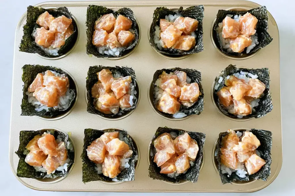 Baked Salmon Sushi Cups with Spicy Kewpie Mayo 5 Unbaked Baked Salmon Sushi Cups assembled with rice, nori, and salmon in a muffin tin