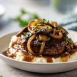 Salisbury Steak with Mushroom Gravy – A Classic Comfort Dish You’ll Keep Coming Back To 7 Close-up of Salisbury steak with mushroom gravy topped with fresh parsley in a modern kitchen, plated with mashed potatoes under bright natural light.