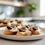 Brie Apple Fig Crostini – The Sweet & Savory Bite Everyone Will Love 7 brie apple fig crostini plated on white dish in modern kitchen