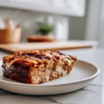 French Onion Meatloaf: A Cozy Twist on a Classic Comfort Dish 7 French Onion Meatloaf served on a white plate with caramelized onions and melted cheese in a modern kitchen setting.
