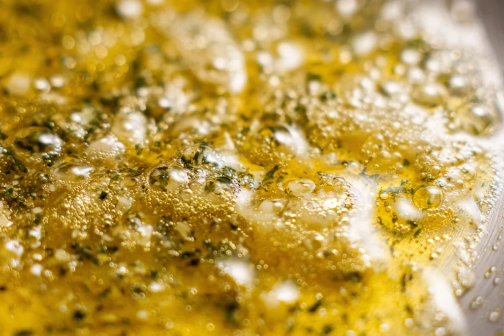 close-up of melted garlic butter sauce bubbling in saucepan for steak bites