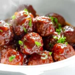 Photorealistic image of meatballs with grape jelly sauce on a modern kitchen counter
