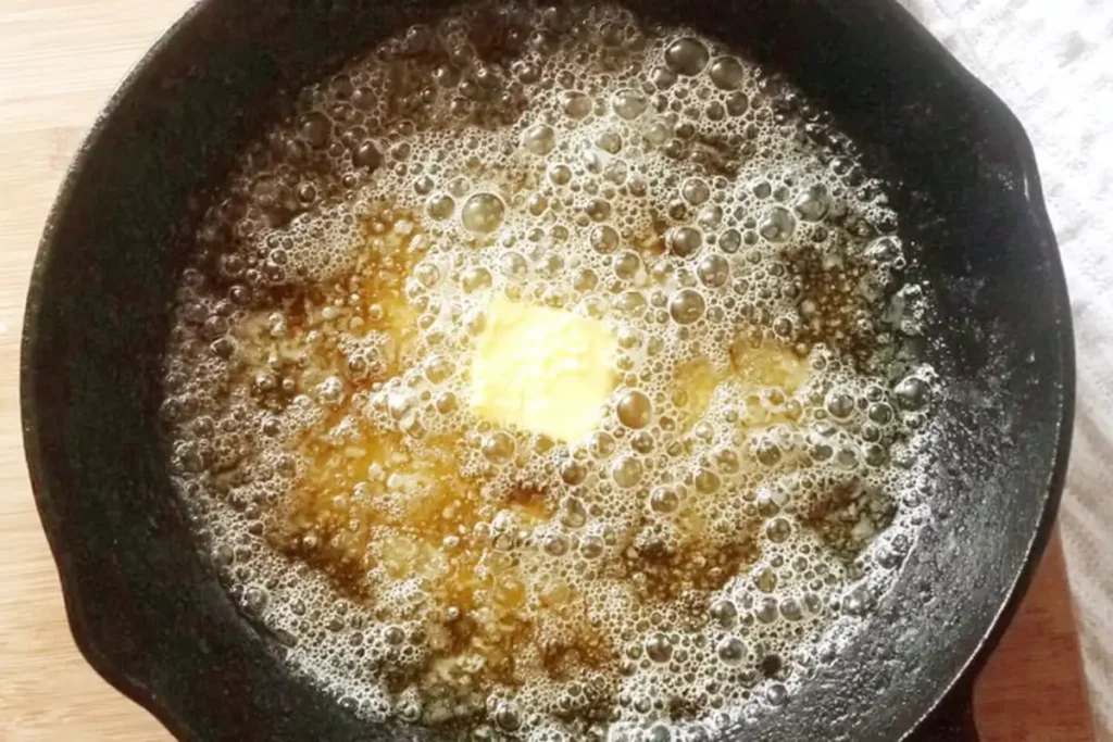 Oil and butter melting in a skillet for pan-fried dumplings with sour cream