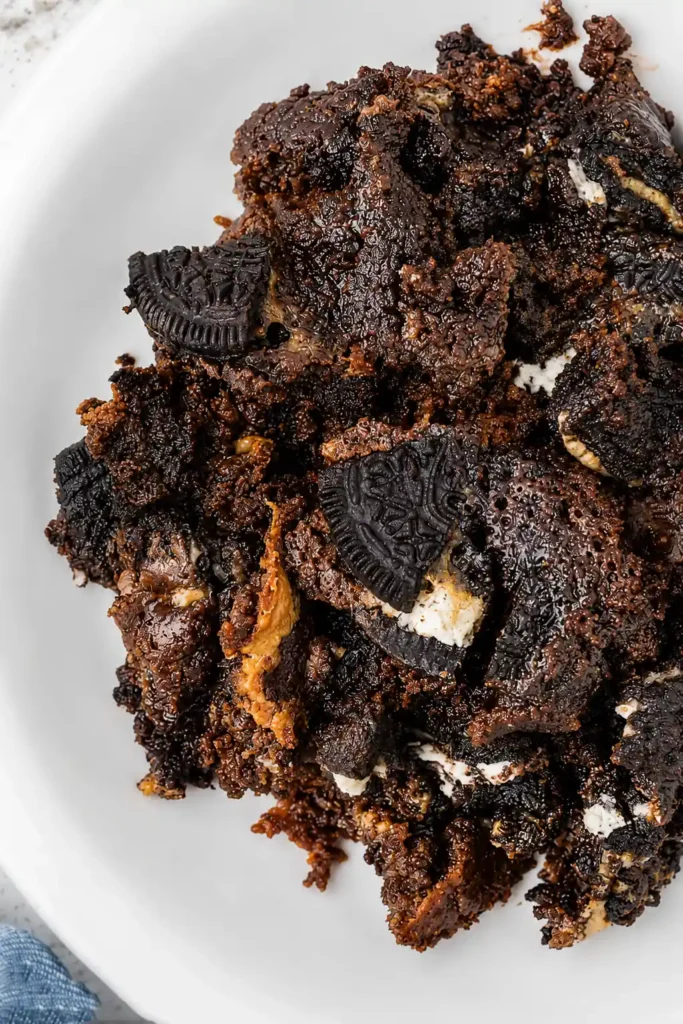 Oreo Dump Cake for an Easy Cookies-and-Cream Dessert 9 Warm Oreo Dump Cake scoop with chocolate crumbs and Oreo cookie pieces