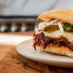 juicy pulled beef sandwich on a modern kitchen counter with melted cheese and coleslaw