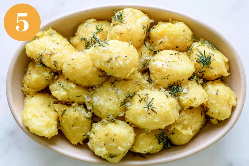 Rosemary Infused Roast Potatoes with Golden Crispy Edges 7 Seasoned rosemary infused roast potatoes arranged in a dish before roasting