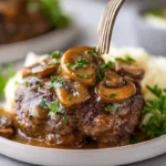 Salisbury steak with mushroom gravy on a white plate in modern kitchen, bright natural light