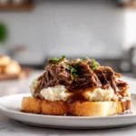 Slow Cooker Beef Manhattan – The Ultimate Comfort Food Classic Made Easy 7 Photorealistic close-up of Slow Cooker Beef Manhattan with mashed potatoes, gravy, and toast on a modern kitchen countertop in natural light.