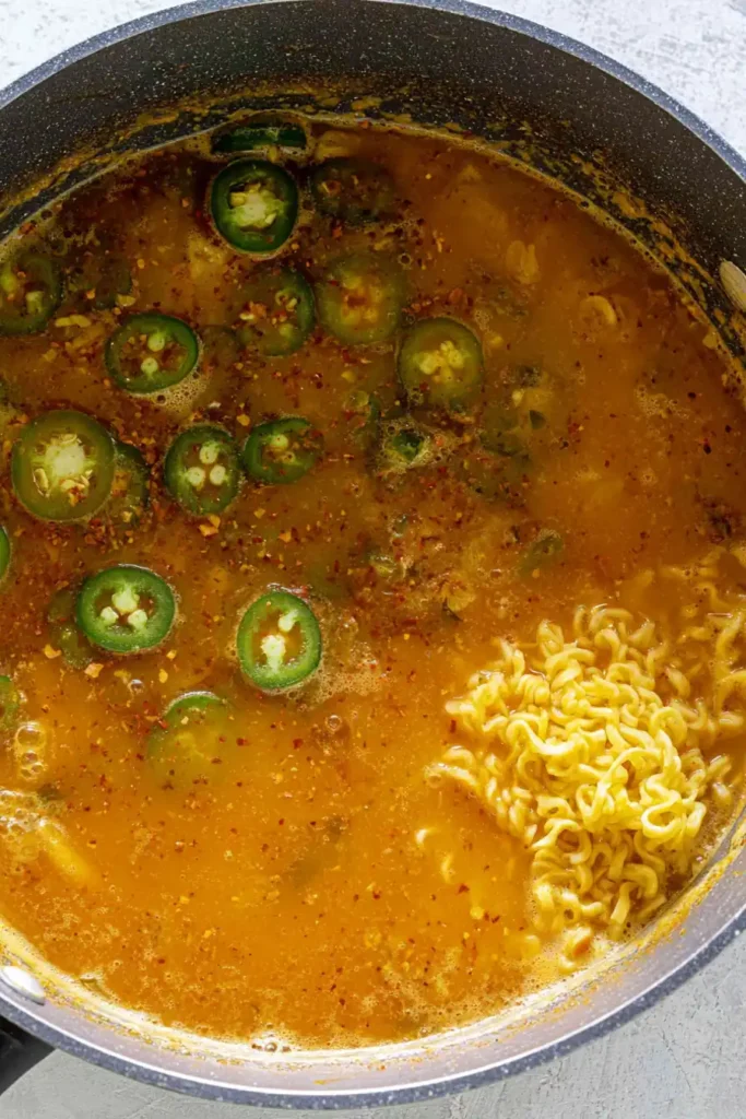 Spicy Ramen Noodles With Shrimp and a Fiery Homemade Broth 3 Spicy ramen noodles beginning to soften in simmering gochujang and serrano broth