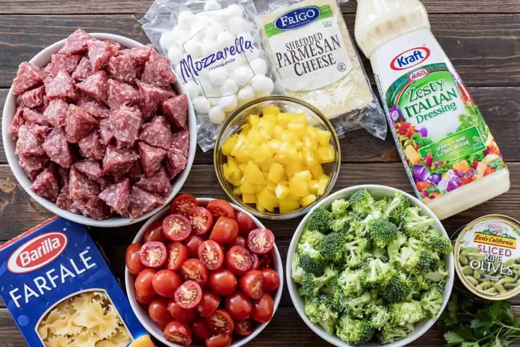 Bow Tie Pasta Salad with Salami, Mozzarella, and Italian Dressing 2 Bow Tie Pasta Salad ingredients with salami, mozzarella, vegetables, and Italian dressing