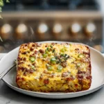 golden breakfast casserole slice on white plate in modern kitchen under natural daylight