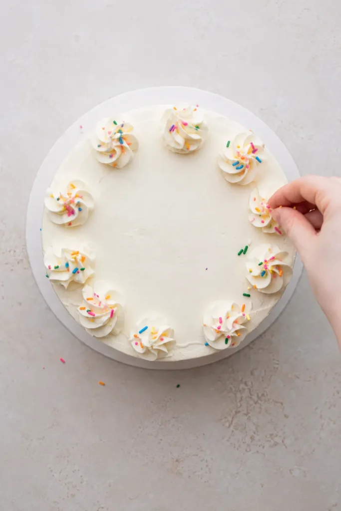 Colorful Layer Cake with Six Bright Celebration Layers 16 Buttercream rosettes and rainbow sprinkles on colorful layer cake