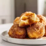 freshly baked caramel apple pie bombs on white plate with gooey caramel center