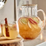 Caramel Apple Punch served in glass pitcher on modern kitchen counter