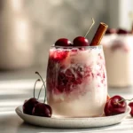 Cherry Earl Grey Milk Tea garnished with fresh cherries and cinnamon stick, vibrant drink with creamy texture