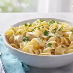 Photorealistic plated chicken buttered noodles in a modern kitchen