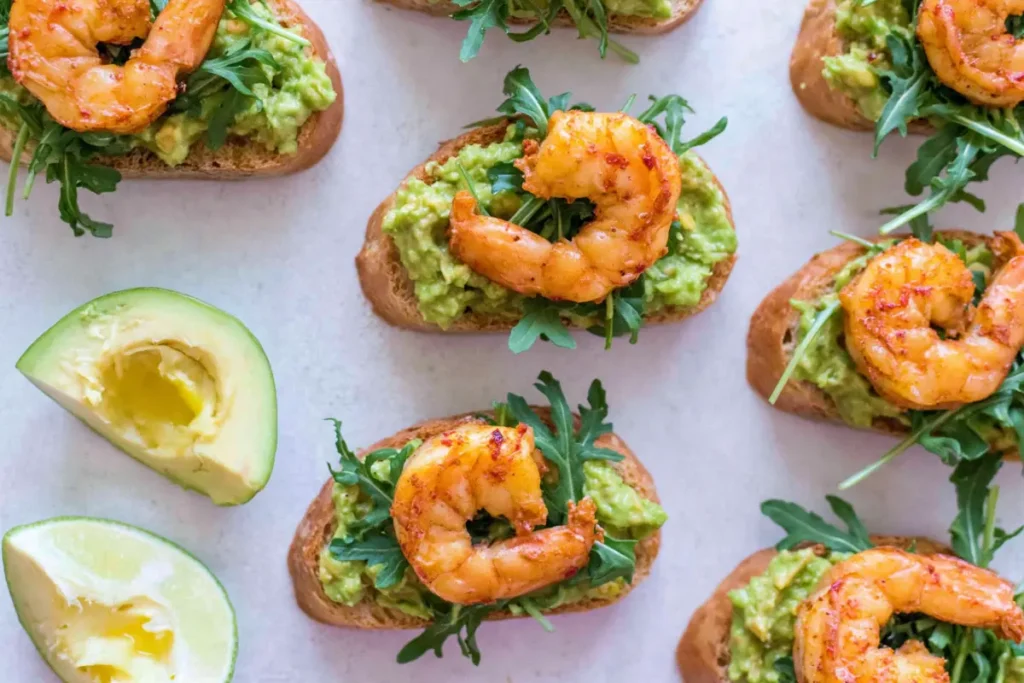 Garlic Shrimp Avocado Crostini for a Crisp, Creamy Party Bite 8 Garlic Shrimp Avocado Crostini party platter with lime, arugula, and toasted baguette