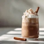 Iced Mexican Coffee Mocha topped with whipped cream and cinnamon stick in a modern kitchen setting