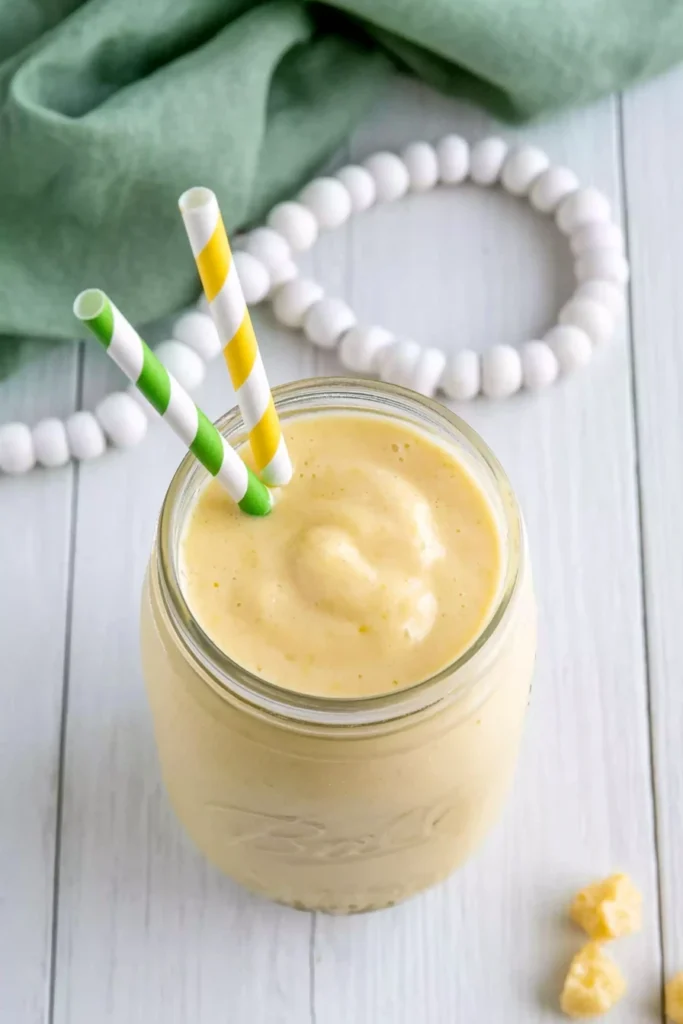 Pineapple orange smoothie served immediately with fresh pineapple chunks