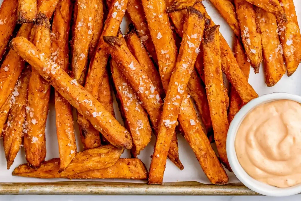 Seasoned Oven Baked Sweet Potato Fries on a sheet pan with dipping sauce
