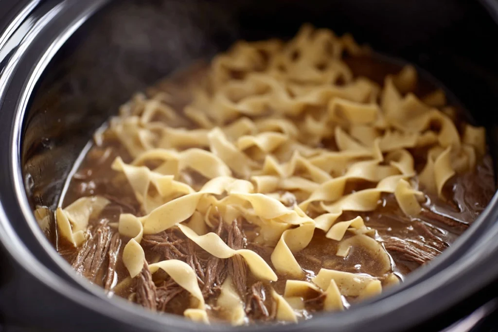 egg noodles added to slow cooker beef and noodles during final cooking stage