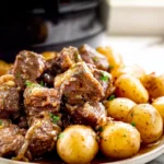 Slow Cooker Garlic Butter Beef Bites Potatoes plated with tender beef and golden potatoes in butter sauce