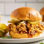 Finished Slow Cooker Hot Honey Chicken Sandwiches on plate in modern kitchen
