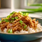 Photorealistic hero shot of Slow Cooker Sweet Chili Chicken served with sauce and garnish