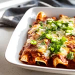 beef enchiladas plated with melted cheese and enchilada sauce
