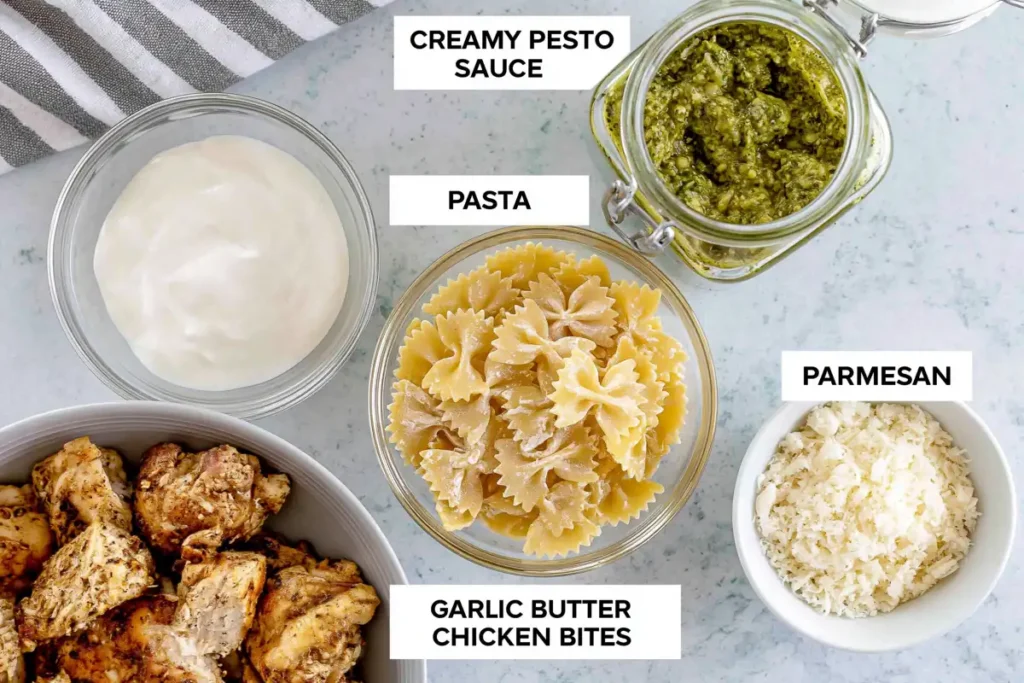 Chicken Pesto Pasta with a Creamy 30-Minute Sauce 2 Chicken Pesto Pasta ingredients with chicken, pasta, basil pesto, cream, Parmesan, cherry tomatoes, and seasonings