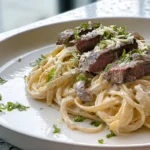 Creamy Garlic Butter Steak & Pasta served on a modern plate with rich sauce