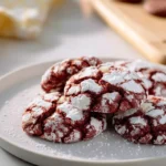 red velvet crinkle cookies with powdered sugar cracks on a modern plate