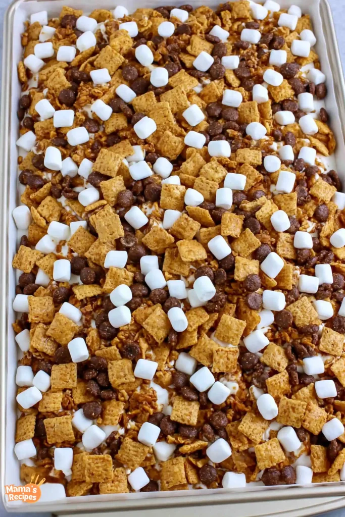 S’mores Snack Mix for an Easy No-Bake Treat 5 S’mores Snack Mix cereal and marshmallows spread on a baking sheet