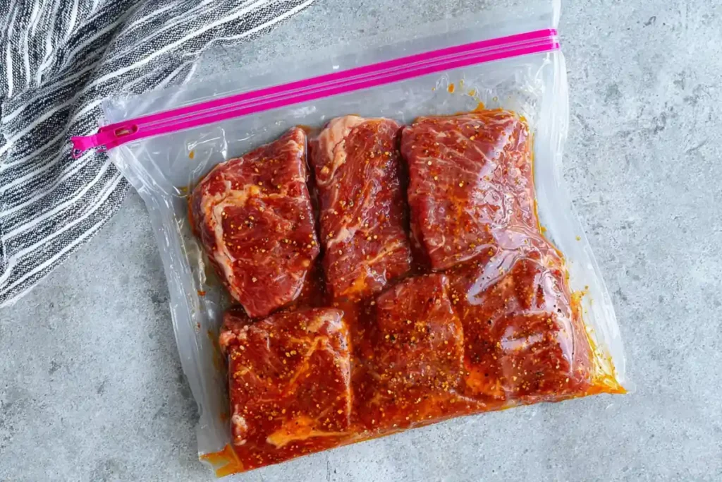 Steak marinating in chipotle steak seasoning inside a resealable bag