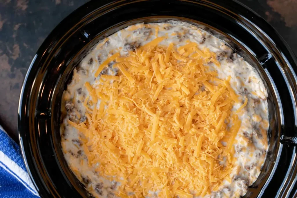 Layered Slow Cooker Hamburger Casserole with potatoes ground beef mushroom sauce and shredded cheese