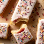 Mohamed Ayad's Pop Tart Cookie Bars Recipe with strawberry filling, vanilla icing, and rainbow sprinkles