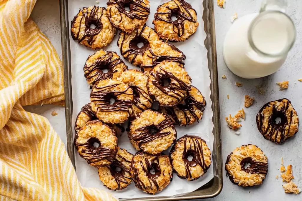 Homemade Samoas Cookies Copycat on a sheet pan with chocolate drizzle and milk