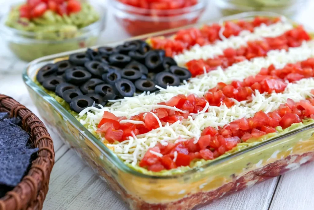 Full dish of American flag layered taco dip with guacamole and fresh toppings