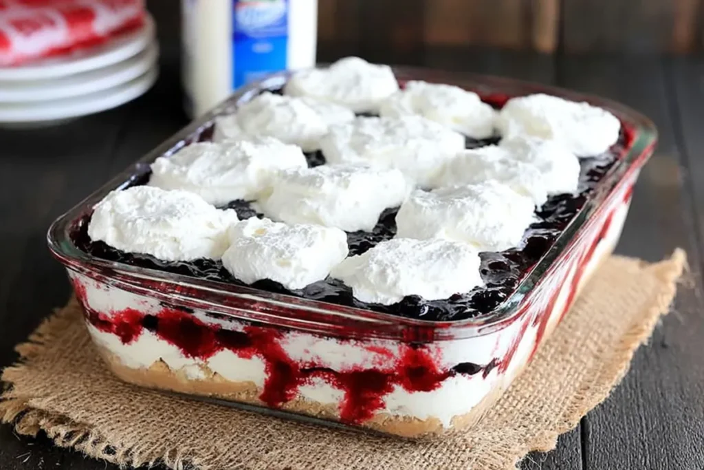 Final cream layer added to mixed berry yum yum with blueberry filling